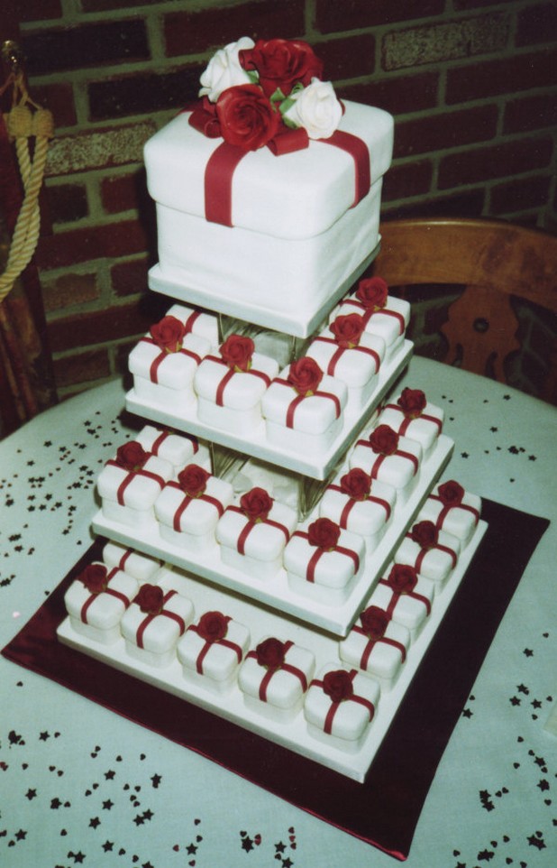 white gift box wedding cake with red ribbons