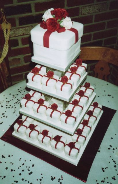 white gift box wedding cake with red ribbons