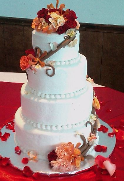 Round 4 tier white wedding cake with fresh flowers and petals.JPG