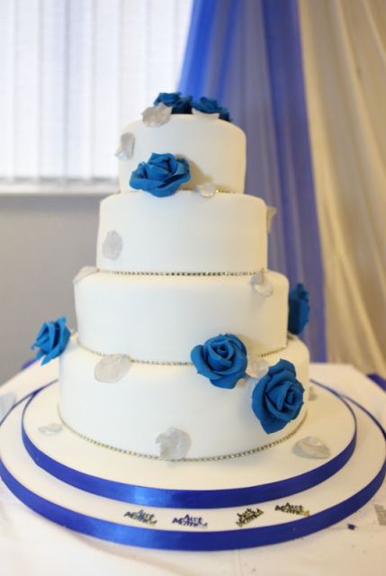 4 tier round white wedding cake with indigo roses and crystal bands.JPG