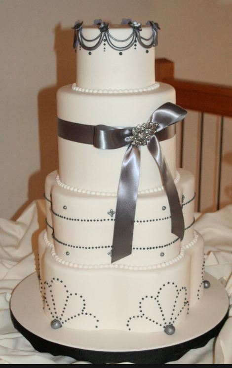 Four tier ivory wedding cake with silver bow.JPG