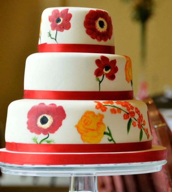 3 tier round white wedding cake with red bands and painted flowers.JPG