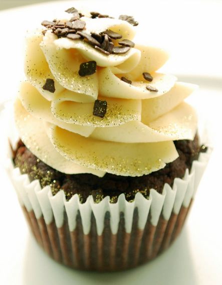 Chocolate cupcake with white cream on top with chocolate bits.JPG