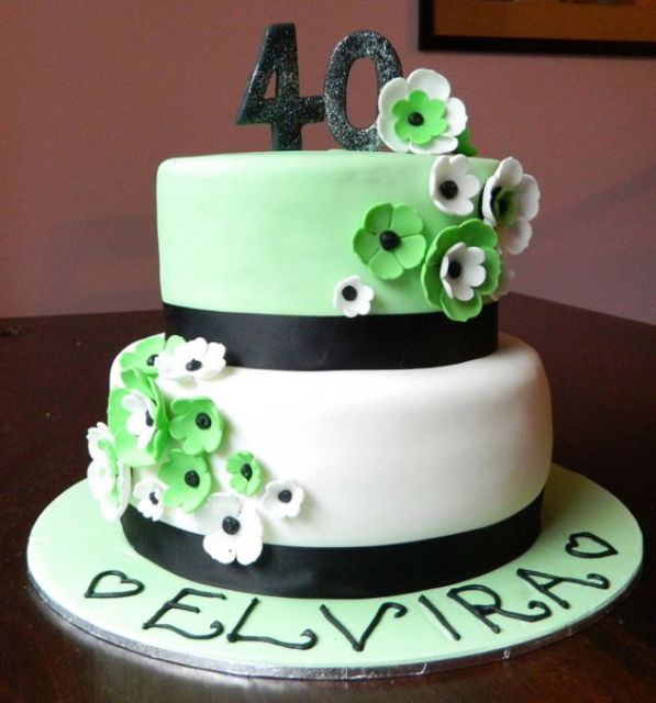 Two tier round white 40th birthday cake with green and white flowers.JPG