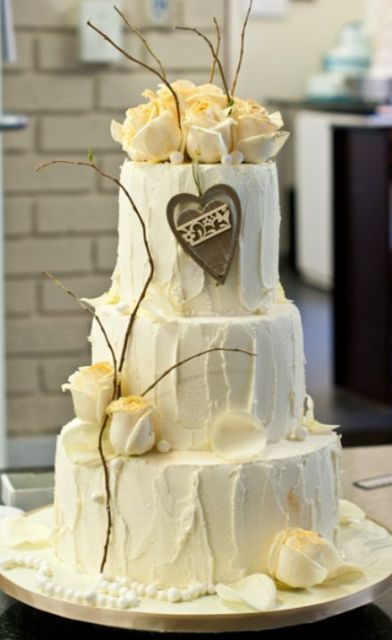 Triple tier round white cream wedding cake with white roses on top and chocolate heart.JPG