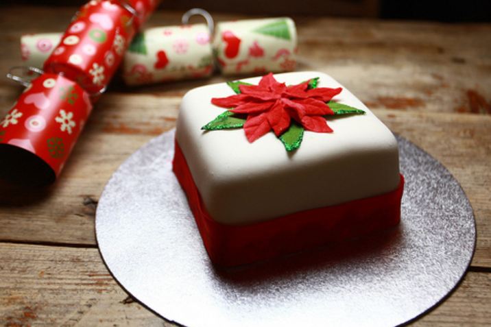 Mini white Christmas cake with red leaves on top.JPG