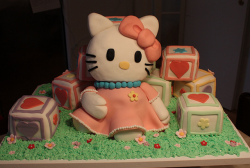 Hello Kitty cakes sitting on the grass surrounding with cubes.PNG
