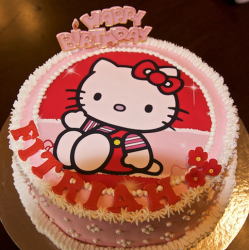 Red and pink Hello Kitty cakes with hello kitty print and small white and red flowers.PNG