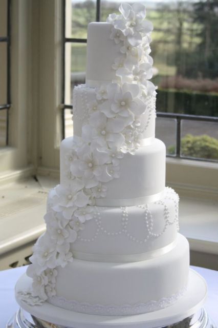 5 tier round white wedding cake with white flowers draping down.JPG