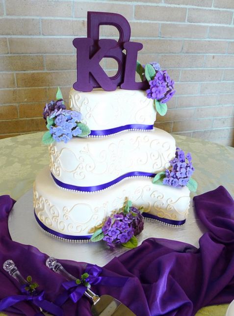 Curvy 3 tier wedding cake with purple letter topper.JPG
