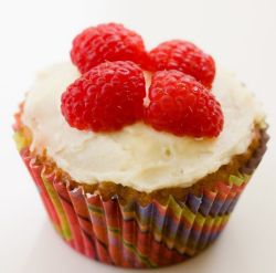 Cupcake with white cream and 4 fresh rasberries on top.JPG