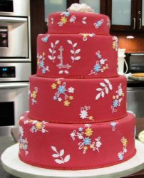 Red round 4 tier wedding cake with floral decor and monogram.JPG