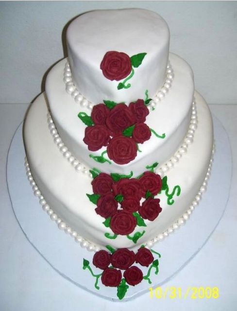 Heart-shaped 3 tier wedding cake with rose pedals and pearls.jpg