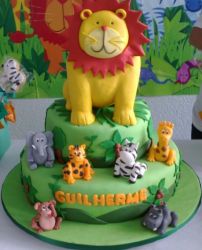 2 tier green safari theme cake with large lion on top along with other animals surrounding.JPG
