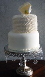 2 tier white round wedding cake with pearl beaded second tier and shell topper.JPG