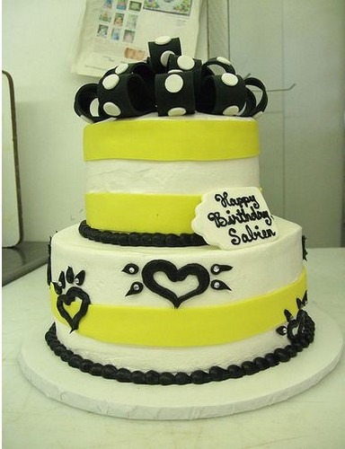 White birthday cake with yellow ribbons and black decor.jpg