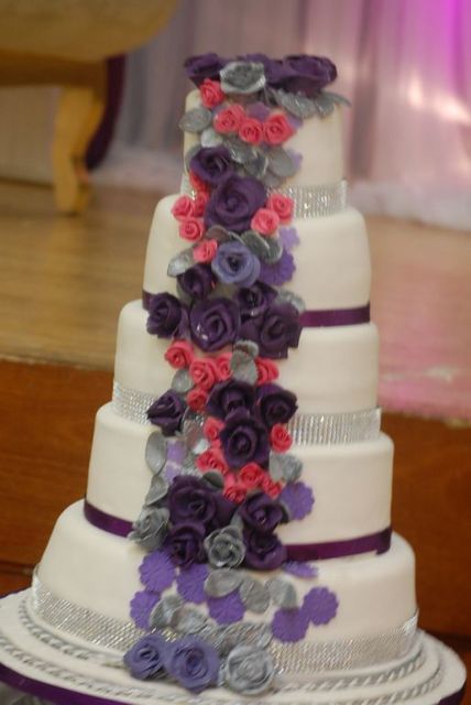 5 tier round white wedding cake with diamond bands and flowing flowers.JPG
