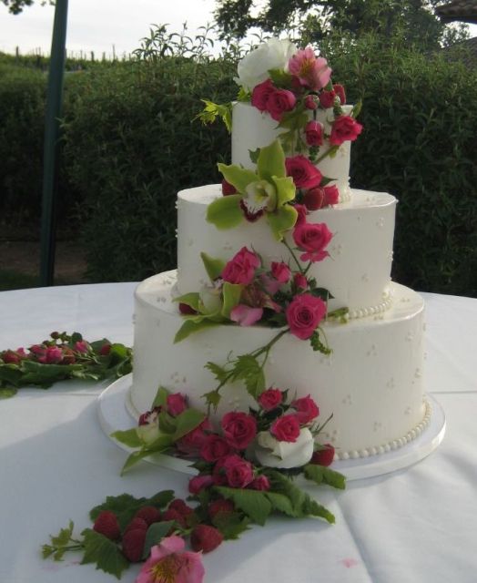 Three tier round wedding cake with fresh rose pedals and strawberries.JPG