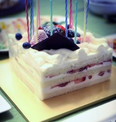 Square cut birthday cake with fresh strawberries and cream in between layers and fresh berries on top.JPG