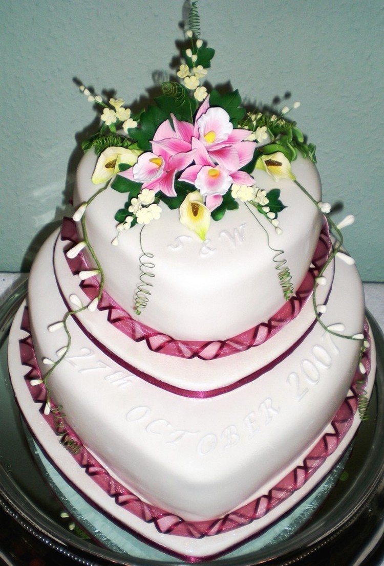 Heart shaped wedding cake with flowers topper