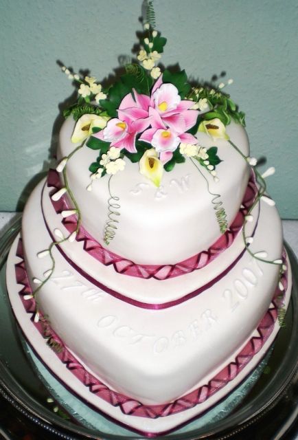 Heart shaped wedding cake with flowers topper