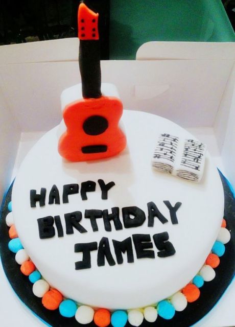 Music theme round white cake with red guitar and music book.JPG